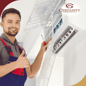 A smiling technician giving a thumbs-up while inspecting or servicing an air conditioning unit.