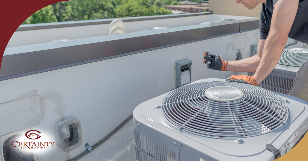 HVAC technician inspecting rooftop air conditioning units on commercial building.